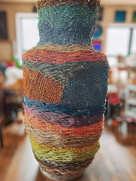 Outdoor public art, six foot multi-colored woven rope basket sculpture.