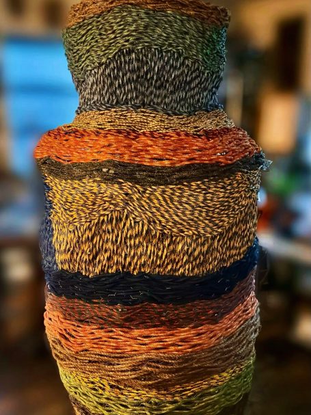 Outdoor public art, six foot multi-colored woven rope basket sculpture.