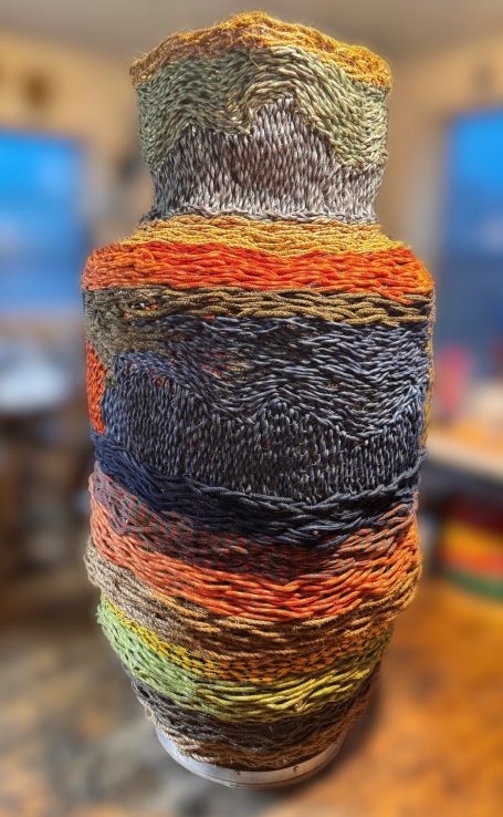 Outdoor public art, six foot multi-colored woven rope basket sculpture.